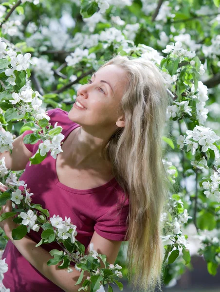 Ung attraktiv kvinna står nära det blommande äppelträdet — Stockfoto