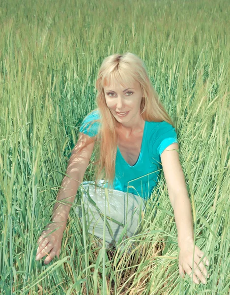 Die glückliche junge Frau im Bereich der grünen Ohren, mit Retro-Effekt — Stockfoto