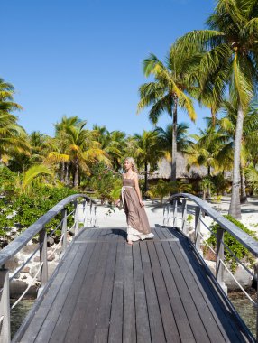 ahşap köprü deniz kenarında uzun elbiseli güzel bir kadın.