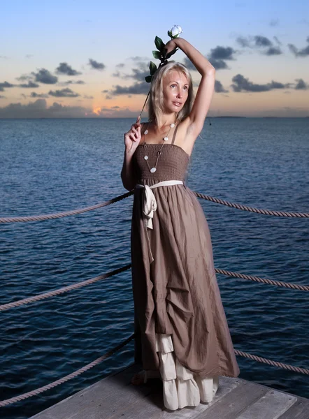 La giovane bella donna su una piattaforma di legno sul mare — Foto Stock