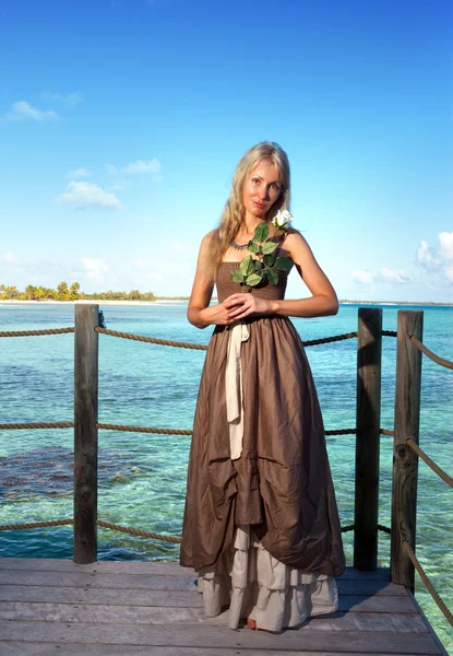 La giovane bella donna su una piattaforma di legno sul mare — Foto Stock