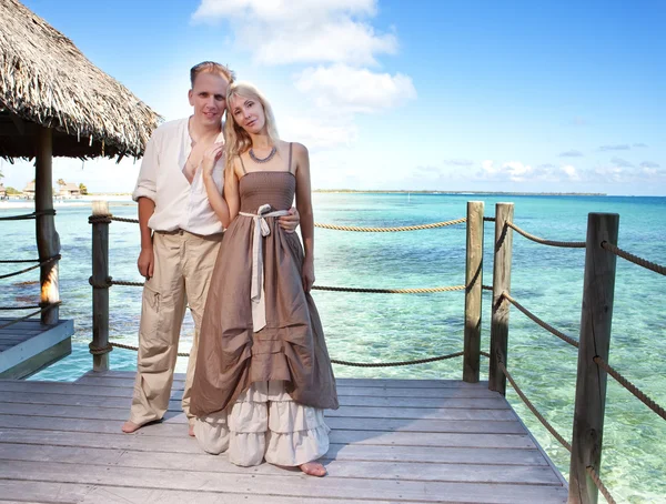 Loving couple on a wooden platform over the sea on the tropical island — Stock Photo, Image