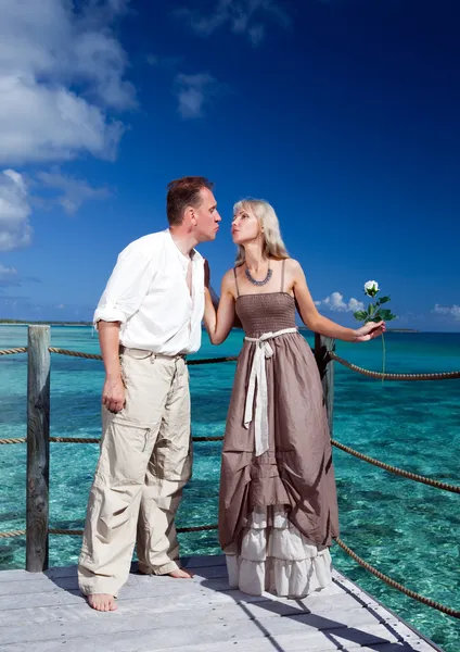 Couple amoureux sur une plateforme en bois au-dessus de la mer sur l'île tropicale — Photo