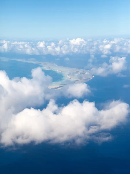 Polynesië. de atol ring in Oceaan is zichtbaar door wolken. Luchtfoto. — Stockfoto