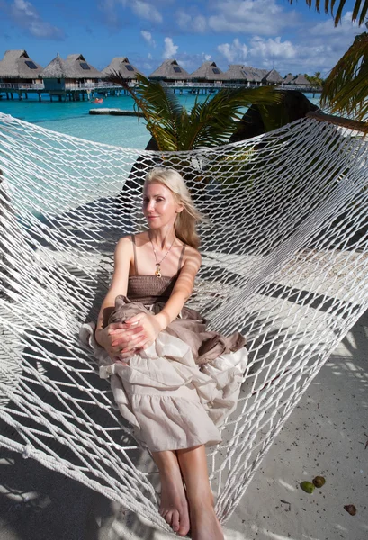 The beautiful woman in a long sundress in a hammock on a sea backgroun — Stock Photo, Image