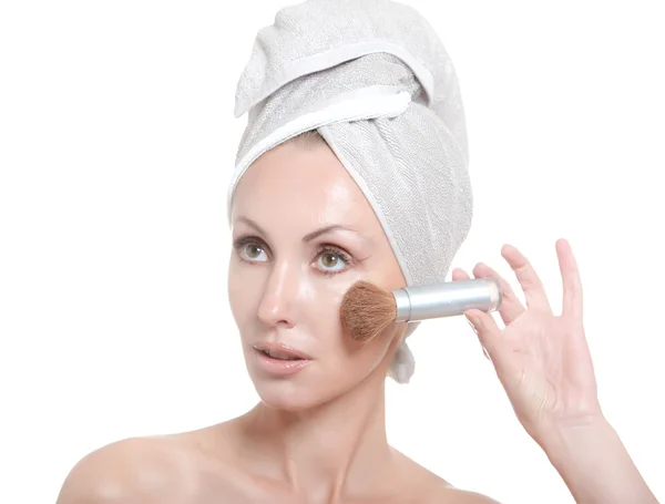 De mooie jonge vrouw in de handdoek met een cosmetische borstel — Stockfoto