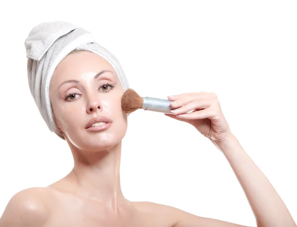 De mooie jonge vrouw in de handdoek met een cosmetische borstel — Stockfoto