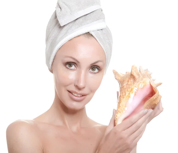 Het mooie meisje in een handdoek op het hoofd met een grote zee-shell — Stockfoto