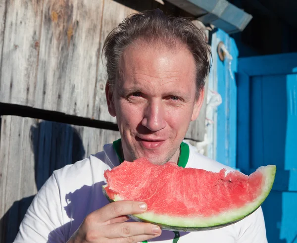 O homem feliz com um pedaço de uma melancia — Fotografia de Stock
