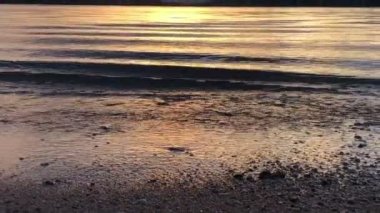 Tropikal denizde gün doğumu, kumlu sahilde dalgalar, ufuktaki dağların üzerinde güneş batışı, Dolly Zoom