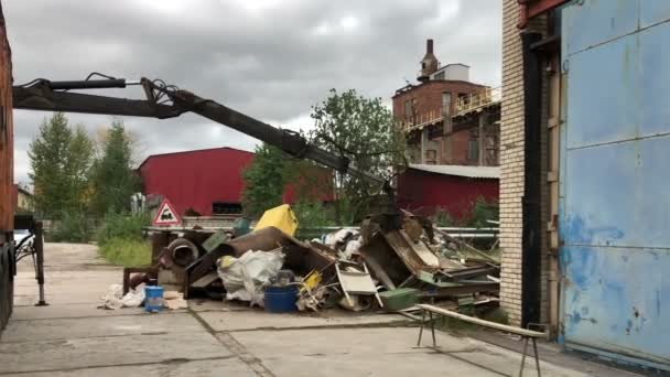 Hydraulic claw manipulator carrrying old metal scrap and loading it in high pressure machine. Concept of metal recycling — Stock Video