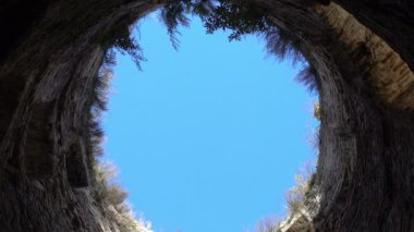 Aşağıdaki mavi gökyüzünün taş duvarlarla çevrili görüntüsü, özgürlük ve mutluluk umudu, akşamları bir ortaçağ kalesinin kulesi. Izborsk şehri, Pskov bölgesi, Rusya.