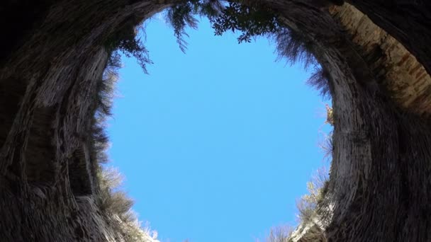 Pohled ze spodní modré oblohy obklopený kamennými zdmi, naděje na svobodu a štěstí, věž středověké pevnosti ve večerních hodinách. Město Izborsk, Pskov, Rusko. — Stock video