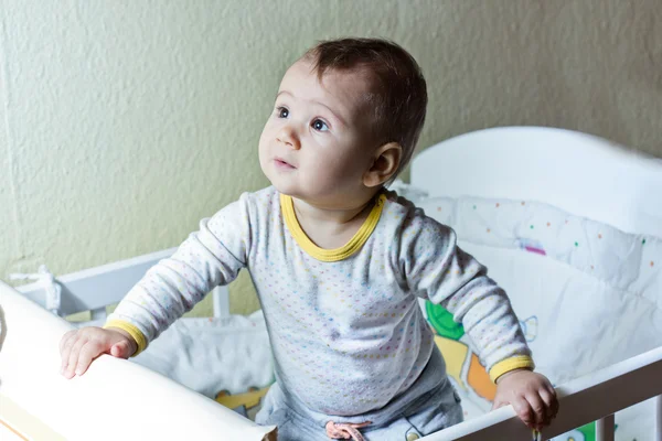 Cute baby girl in her cot — Stock Photo, Image