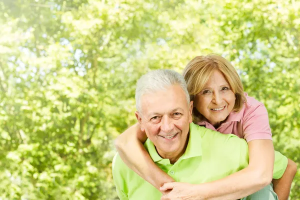 Gelukkig senior man geven piggyback rit — Stockfoto