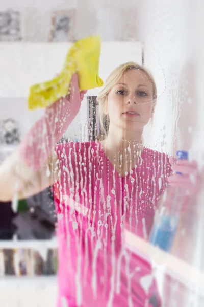 Vrouw wassen het vensterglas — Stockfoto