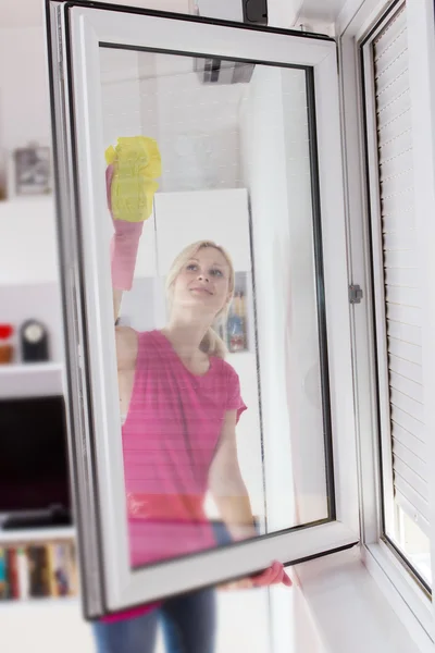 Femme au foyer avec gant de protection laver le verre de fenêtre — Photo