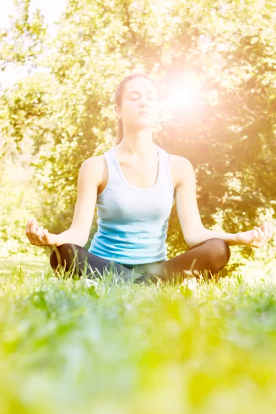 Young woman meditating in the park — Stock Photo, Image