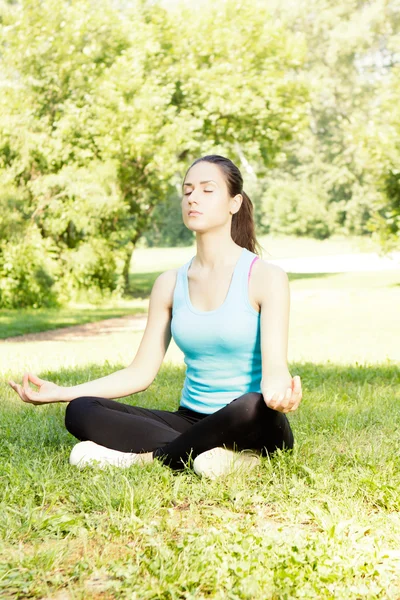 Güzel bir genç kadın yoga yaparken — Stok fotoğraf