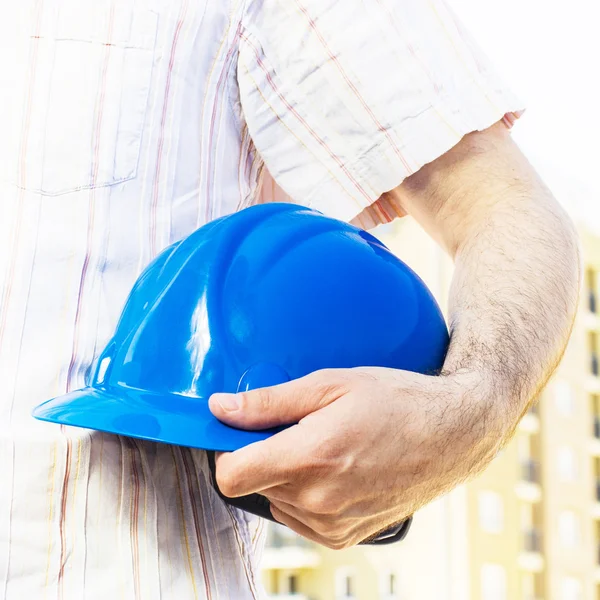 Construction worker holding blue hard hat — Stock Photo, Image