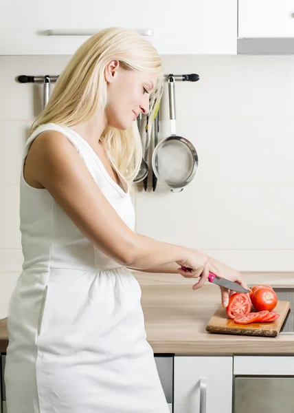 Porträt einer jungen blonden Frau, die Gemüse zubereitet — Stockfoto