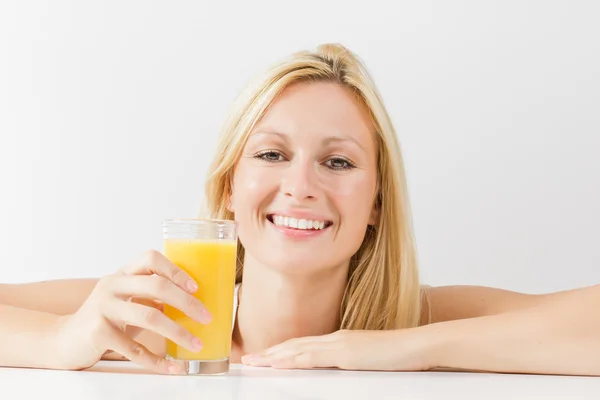 Giovane donna sorridente con succo d'arancia — Foto Stock