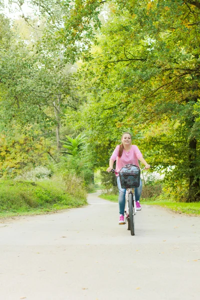 Студентська дівчина їде на велосипеді на відкритому повітрі . — стокове фото