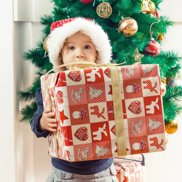 Liten flicka som håller en julklapp — Stockfoto