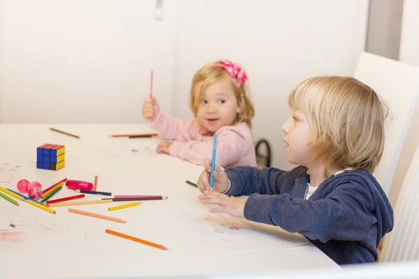 Küçük kız ve erkek renkli boya kalemi ile çizim — Stok fotoğraf