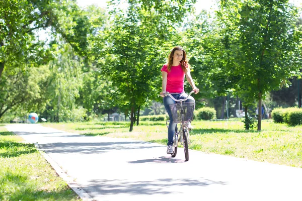 Mujer joven montando una bicicleta — Foto de Stock