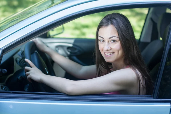 Mujer joven y feliz conduciendo un coche — Foto de Stock