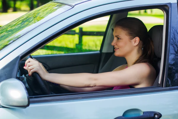 Gelukkig jonge vrouw besturen van een auto — Stockfoto