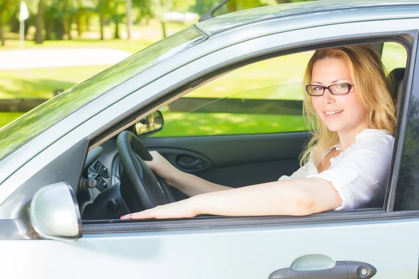 Gelukkig jonge vrouw besturen van een auto — Stockfoto