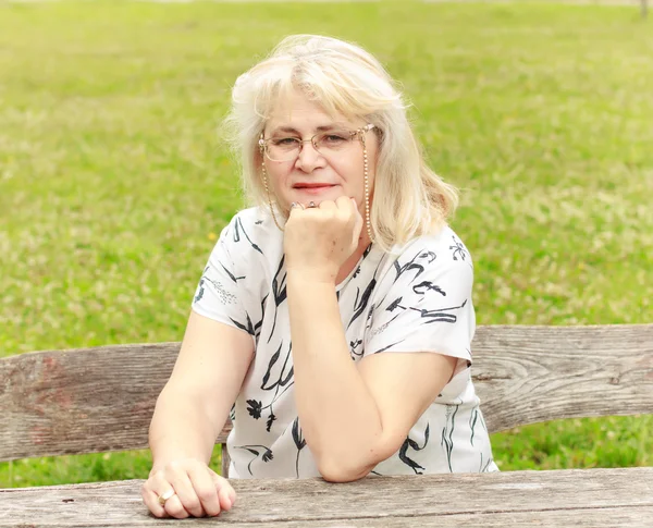 Mosolygó idősebb asszony a parkban — Stock Fotó