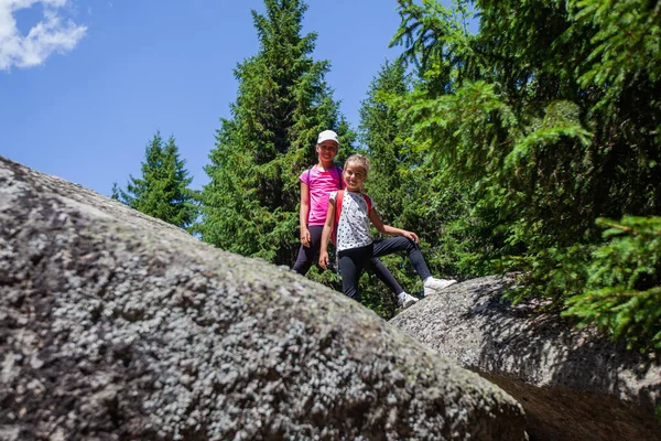 Pikkutytöt Kiipeävät Kallioilla Muodostumista Metsässä Kesäpäivänä — kuvapankkivalokuva