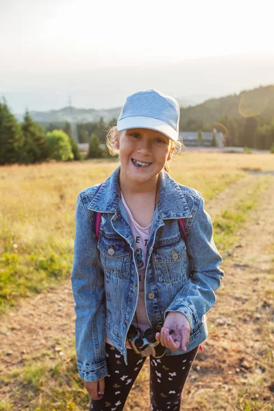 新鮮な熟したブルーベリーを食べる少女ハイカーの肖像画 夏の自然景観 日没の光 — ストック写真