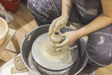 Seramik ressam elleri çömlek çarkındaki kil kalıbını tutuyor. Yaratıcı atölye.