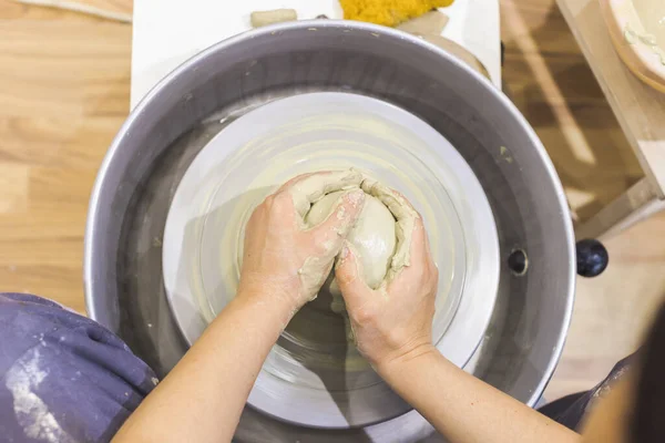 女陶艺家的手在陶瓷轮上塑造粘土 独创的手工工艺 顶视图 陶瓷工作室 — 图库照片