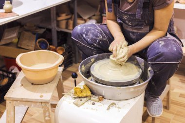 Çömlek atölyesi. Kadın seramik sanatçısı kil çömlek kalıbını çıkarıyor. Yaratıcı el yapımı zanaat. 