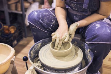 Çömlek atölyesi. Kadın seramik sanatçısı kil çömlek kalıbını çıkarıyor. Yaratıcı el yapımı zanaat. 