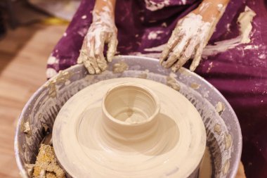 Çömlek atölyesi. Kadın seramik sanatçısı kil çömlek kalıbını çıkarıyor. Yaratıcı el yapımı zanaat. 