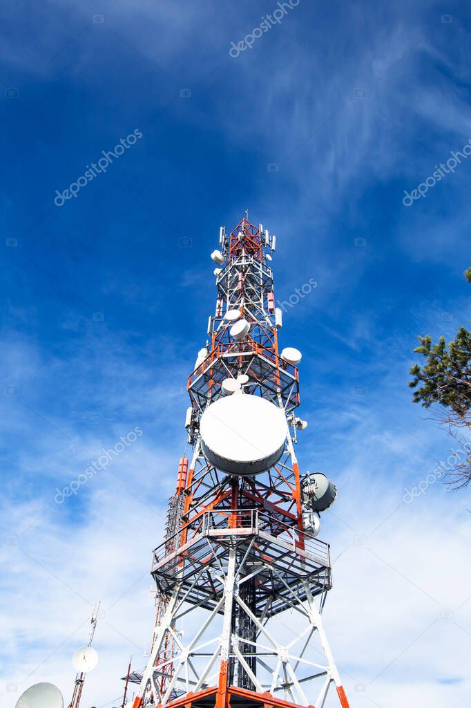 Telecommunication tower. Communication and connection. Wireless antene. Blue sky with clouds in background.