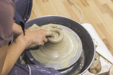 Çömlek atölyesi. Kadın seramik sanatçısı kil çömlek kalıbını çıkarıyor. Yaratıcı el yapımı zanaat. 