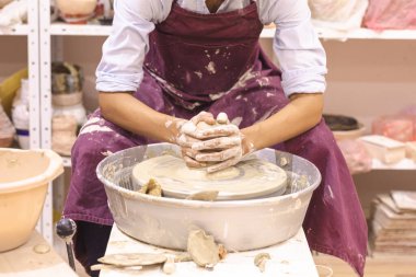 Çömlek atölyesi. Kadın seramik sanatçısı kil çömlek kalıbını çıkarıyor. Yaratıcı el yapımı zanaat. 