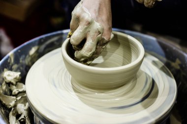 Çömlek atölyesi. Kadın seramik sanatçısı kil çömlek kalıbını çıkarıyor. Yaratıcı el yapımı zanaat. 