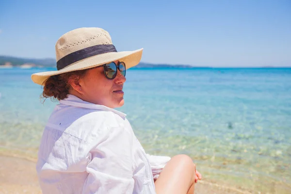 Beyaz Gömlekli Şapkalı Mutlu Kadın Kumsalda Dinleniyor Deniz Manzarasının Tadını — Stok fotoğraf