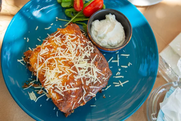 Traditional Greek moussaka, delicious Greece food, the portion served on the plate at a restaurant.