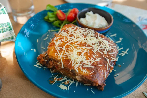 Traditional Greek moussaka, delicious Greece food, the portion served on the plate at a restaurant.