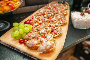 Delicious bruschetta, starter dish, served on wooden board with grape, snack or appetizer.