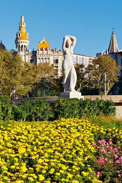 Estatua pública y flores en Placa Catalunya, Barcelona —  Fotos de Stock